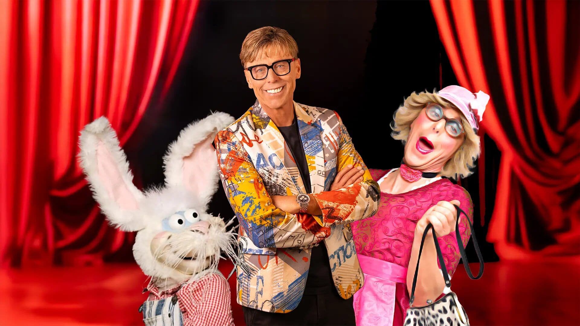 Comedy-Auftritt mit zwei Handpuppen vor rotem Vorhang
